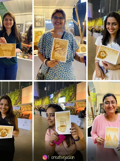 A collection of proud artists showing off their coffee paintings at an evening art event, with subjects ranging from lions to landscapes.