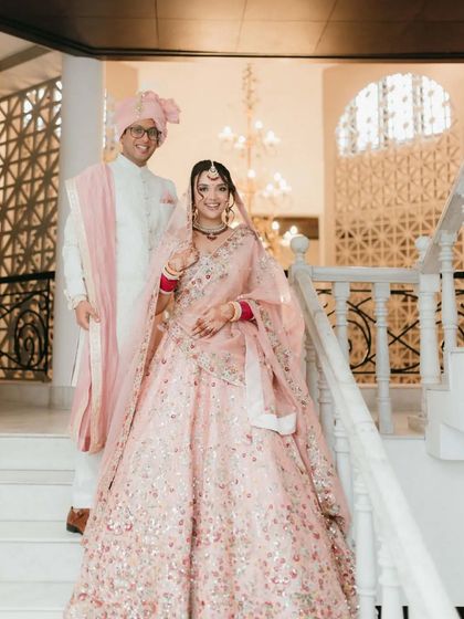 A classic, elegant portrait of the bride and groom on a grand staircase.