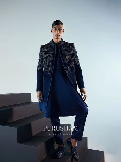 Luxury ensembles setting standards for sophistication. This full-length view of the navy blue velvet bandhgala showcases its elegant drape and the stunning contrast of the silver embroidery.