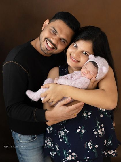 A happy couple with their newborn baby. This classic family portrait is a beautiful way to announce and celebrate their new arrival.