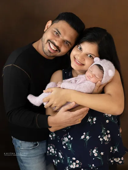 A happy couple with their newborn baby. This classic family portrait is a beautiful way to announce and celebrate their new arrival.