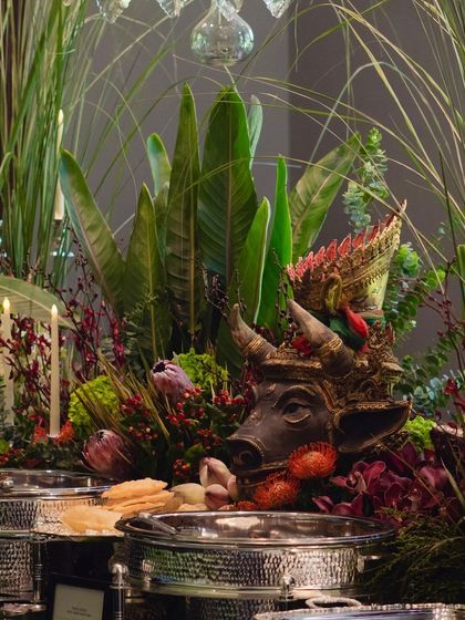 A detail shot of the buffet decor, where cultural artifacts are woven into the floral arrangements, adding a layer of artistry and storytelling to the dining experience.