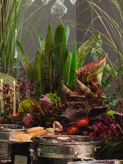 A detail shot of the buffet decor, where cultural artifacts are woven into the floral arrangements, adding a layer of artistry and storytelling to the dining experience.