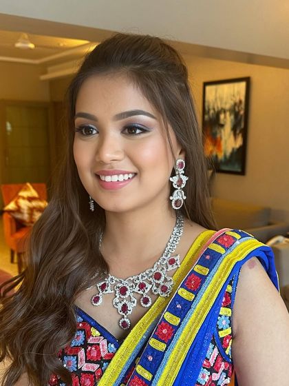 A vibrant and colorful Mehendi look. The bride's multi-colored outfit is complemented by a soft smokey eye and a bright, happy smile.