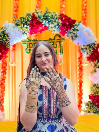 A happy bride with her minimalist bridal mehendi. The design is elegant and not overly dense, perfect for a modern bride.