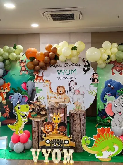 A cute and friendly jungle animal theme with a circular backdrop and a full balloon garland. This setup includes multiple character cutouts and a large light-up number '1'.