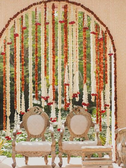 The main seating for the couple at the Mehendi, set against a backdrop of hanging floral strings.
