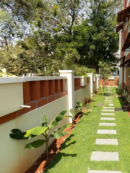 A landscaped path along the compound wall, demonstrating attention to detail in the outdoor spaces.