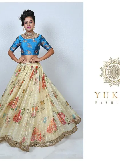 A floral fantasy for a modern celebration. This custom lehenga set features a vibrant blue brocade blouse paired with a light, flowing floral print skirt, ideal for a reception or festive occasion.