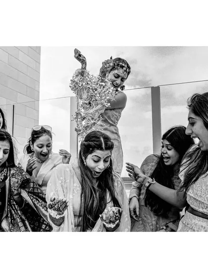 A bride's kalire ceremony with her bridesmaids. This high-energy black and white shot captures the expressions of surprise and joy as the kalire falls, a fun and meaningful tradition.