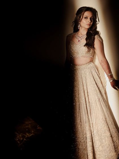 The bride in a moment of quiet elegance. The dramatic lighting creates a beautiful contrast, making her sparkling outfit the star of the show.