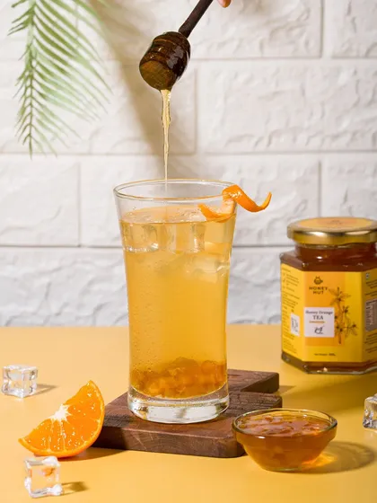 A refreshing glass of iced orange tea made with the brand's concentrate. Beverage photography like this focuses on making the drink look cool and thirst-quenching.
