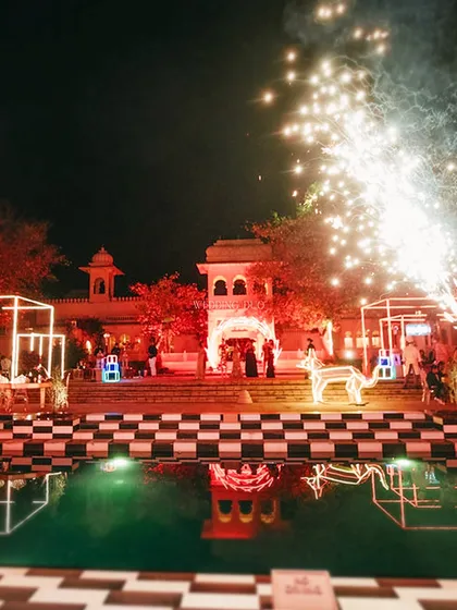 A cocktail night designed as a playground for the senses. This wide shot shows how we used neon-lit structures, a checkered poolside, and dramatic pyrotechnics to create a luxurious and wild atmosphere at The Oberoi Udaivilas.