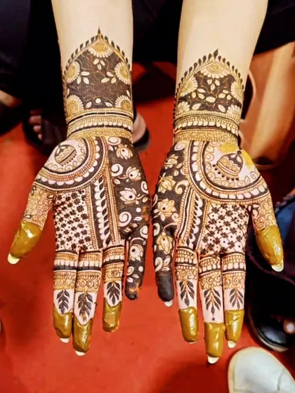This is a beautiful example of a full-hand design with bold floral and leaf patterns. The contrast between the delicate lines and the filled-in areas creates a striking effect.
