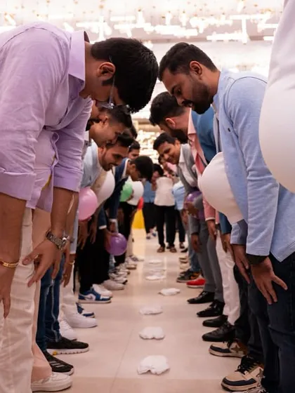 A different angle of the men's balloon game, showing the concentration and fun involved. It’s a great way to get everyone participating.