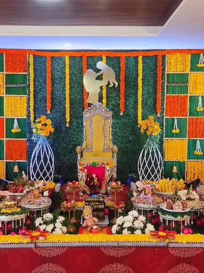 A baby shower setup with a colorful checkered backdrop and a mother-and-child silhouette on the throne, creating a modern yet traditional look.