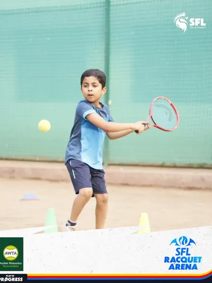 A young beginner learns to connect with the ball. Our coaching for first-timers focuses on making tennis fun and accessible while building a strong technical foundation.
