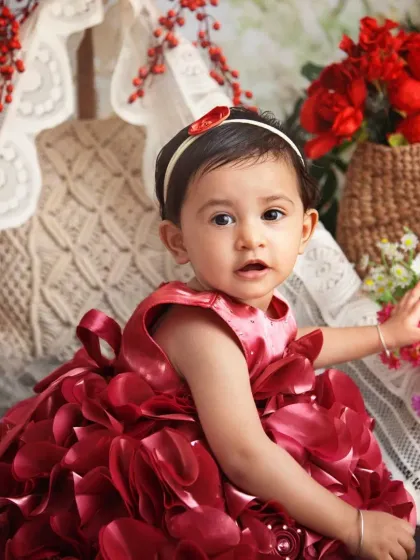 This little lady in her stunning red floral dress is just captivating. I love how the dress complements the red flowers in the boho setup.