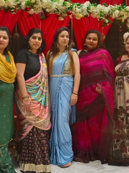 A group of friends and family at an event, with one of our clients looking lovely in a light blue ready-to-wear saree with an embellished belt.