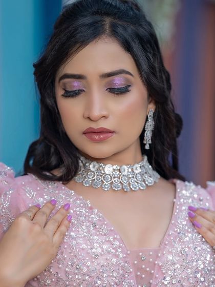 This bride is wearing a delicate American diamond choker with her pastel pink outfit. It's a very elegant and modern choice.