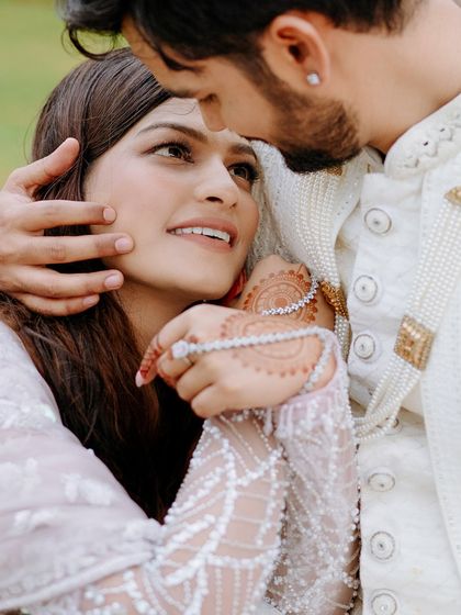 A tender close-up capturing the bride's adoring gaze. This shot focuses on the deep emotion and connection, highlighting the intricate details of her henna and jewelry.