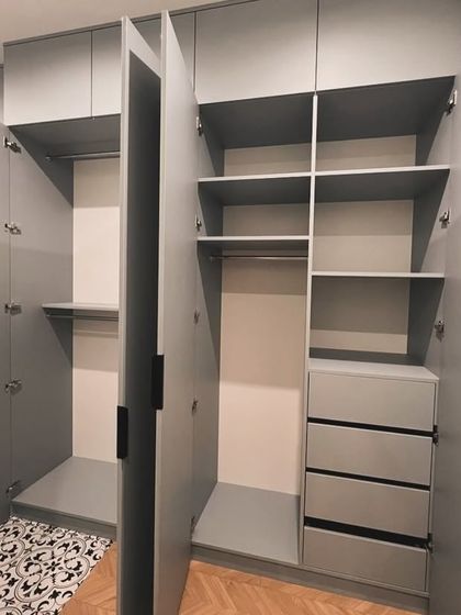 An open view of a modular wardrobe's interior layout in Gurgaon. This design includes a mix of hanging rods, adjustable shelves, and soft-close drawers, providing versatile storage for different types of clothing.