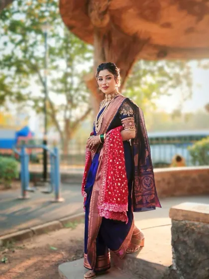 A full-length view of a traditional Maharashtrian bridal look. The rich blue nauvari with a contrasting red shela is a timeless combination that we love to style.