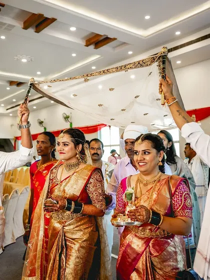 The bride making her entrance under the traditional canopy, looking serene and beautiful.