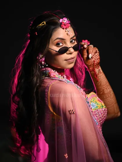 A modern and edgy bridal portrait using dramatic pink lighting and cool sunglasses to create a unique, contemporary look.