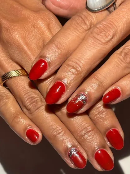 Timeless and bold. A classic red manicure with a touch of silver glitter on the accent nail is a go-to for any celebration.