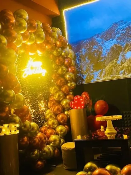 This angle shows the full scope of a birthday celebration in my private theatre, with decorations, props, and a movie playing on the big screen.