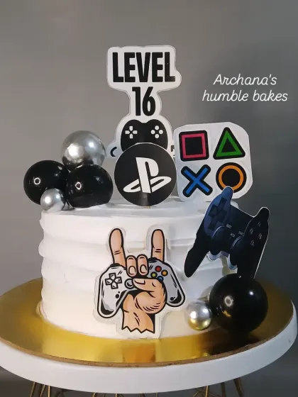 Level up your celebration with this PlayStation themed cake. It's perfect for gamers, featuring controllers, buttons, and a "Level 16" topper.