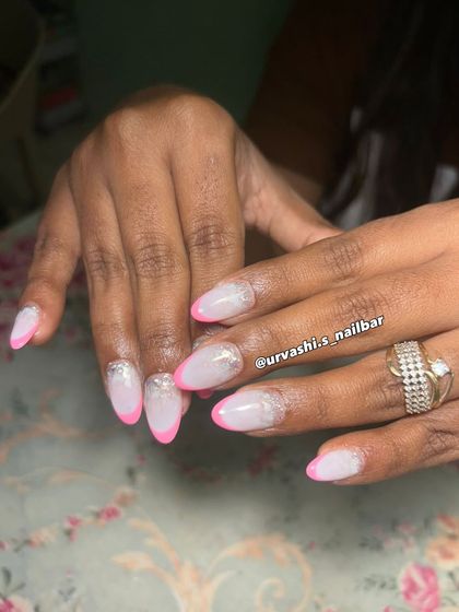 A playful twist on a French manicure with bright pink tips and a touch of silver glitter on a frosted base. It's a fun and chic look, perfect for summer.