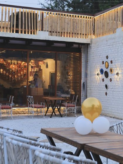 A view of our outdoor patio area during the day. You can see the mix of modern furniture and rustic decor, including our signature wall art.