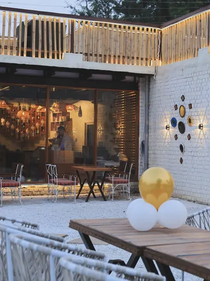 A view of our outdoor patio area during the day. You can see the mix of modern furniture and rustic decor, including our signature wall art.