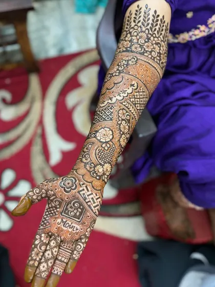 A single-arm view of a bridal design with the name 'Moin' on the palm.