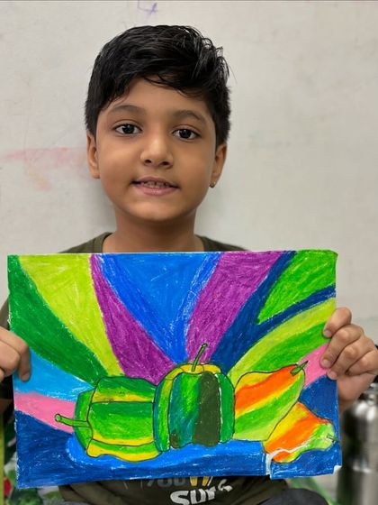 A 5th-grade student displays his still life of vegetables with a dynamic, colourful background. We learn to combine realistic subjects with expressive, abstract elements.