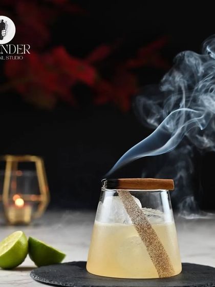A spiced rum punch perfect for winter days. This cocktail is smoked with a cinnamon stick to infuse it with warm, aromatic flavors.