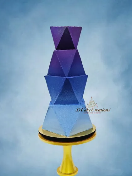 For the modern couple, we create bold, contemporary designs. This futuristic, geometric cake features sharp angles and a striking blue-to-purple ombre effect, designed for the cocktail night of celebrity Divya Agarwal.