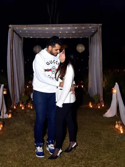 A wide shot showcasing the beautiful, romantic ambiance created for a surprise proposal. We capture the entire scene, from the candlelit path to the decorated canopy, to tell the full story.