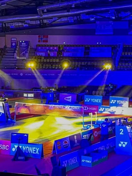 Dramatic lighting highlights the court during the BWF World Junior Badminton Championships. We handle all technicals, including specialized lighting design, to create a broadcast-ready environment.