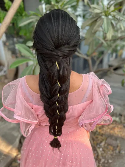 A detailed look at an advanced mermaid braid hairstyle. The intricate weaving and crimped texture create a stunning and unique look for a reception or special event.