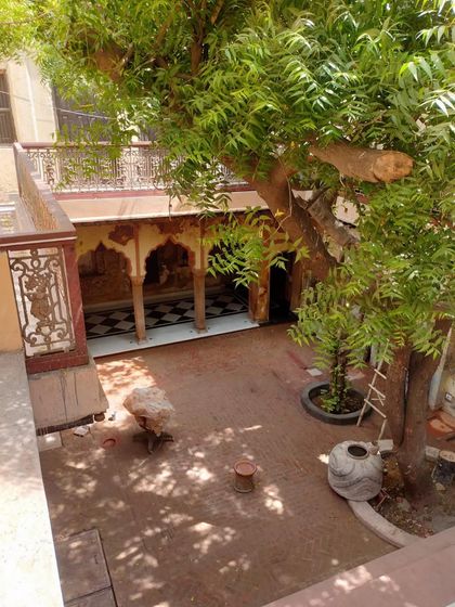 A high-angle view of the courtyard during restoration, showing the interplay of light and shadow on the half-finished surfaces.