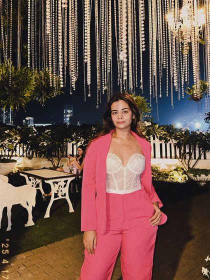 A full-length shot of my pink pantsuit look. The bright color and confident styling are all about having fun with fashion and not being afraid to stand out.