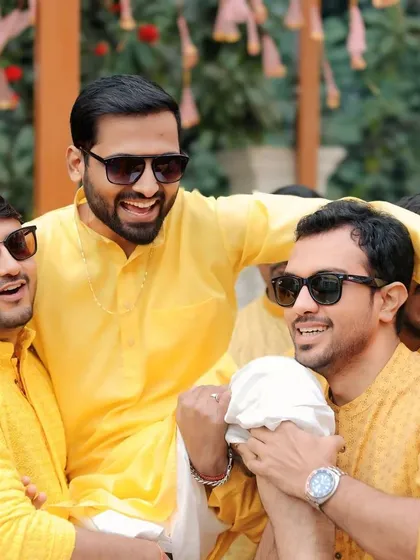 Smiling through every moment of this beautiful journey. The groom is lifted by his friends during the haldi ceremony, a picture of pure joy.
