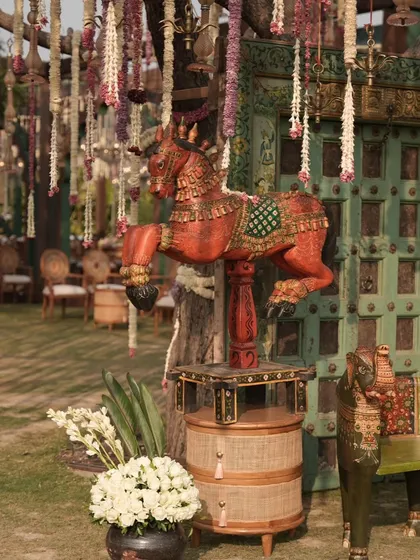 A traditional carved horse statue stands as a decorative element, adding a touch of rustic, regal charm to the outdoor decor.