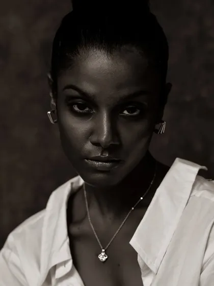 A high-contrast, low-key monochrome portrait. The deep shadows and the intense stare create a dramatic and powerful mood.