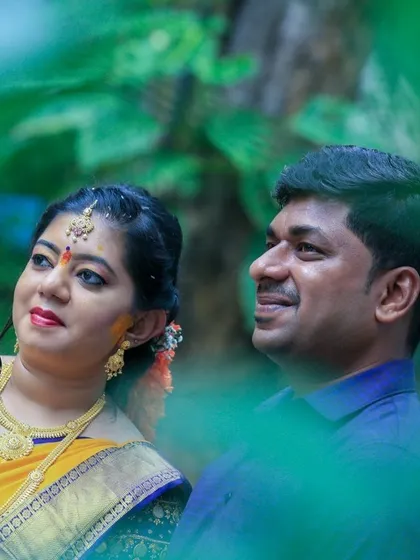 A lovely candid of a couple, framed by green leaves, looking towards their future together.