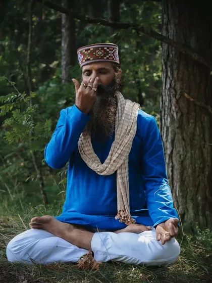 Practicing Nadi Shodhana pranayama (alternate nostril breathing) in the forest. This powerful technique balances the energy channels in the body and calms the mind, helping you to create a state of inner harmony.