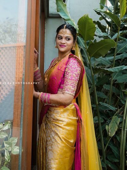 Another angle of the yellow and pink Kanchivaram ensemble, showing how the saree drapes and the way the embroidered blouse catches the light.